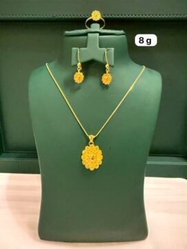 An elegant gold jewelry set adorned with a floral pendant.